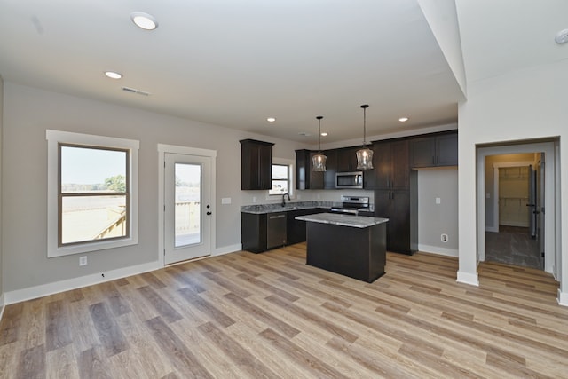 kitchen featuring pendant lighting, light wood-type flooring, dark brown cabinets, a kitchen island, and stainless steel appliances