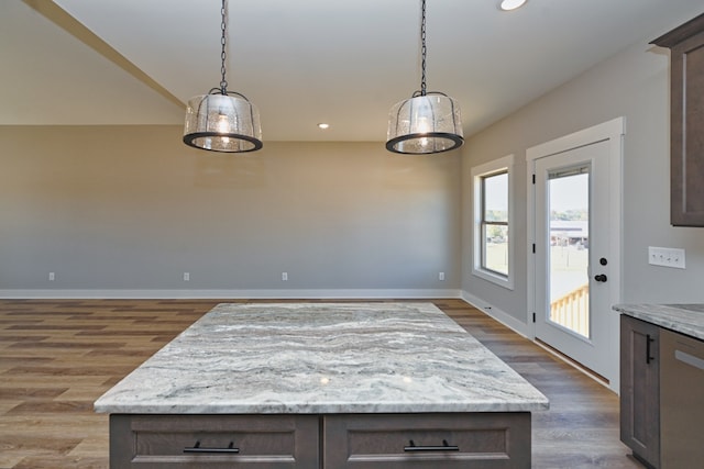 kitchen featuring wood-type flooring, dark brown cabinets, and pendant lighting