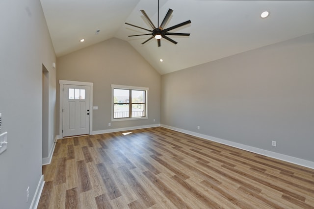 unfurnished living room with ceiling fan, high vaulted ceiling, and light hardwood / wood-style floors