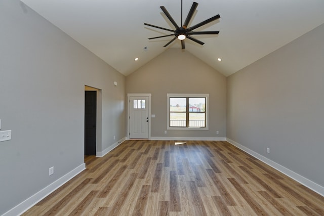 unfurnished living room featuring light wood-type flooring, high vaulted ceiling, and ceiling fan