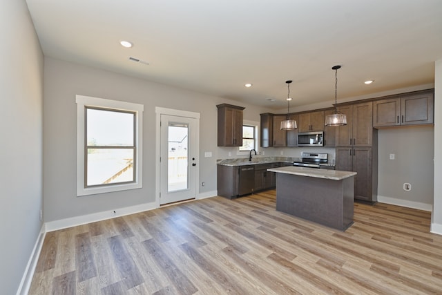 kitchen featuring plenty of natural light, a kitchen island, light hardwood / wood-style floors, and appliances with stainless steel finishes