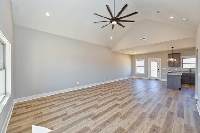 unfurnished living room with ceiling fan, high vaulted ceiling, and light hardwood / wood-style floors