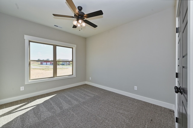 spare room with dark colored carpet and ceiling fan