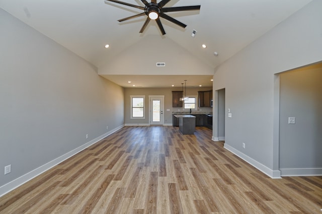 unfurnished living room featuring high vaulted ceiling, light hardwood / wood-style flooring, ceiling fan, and sink