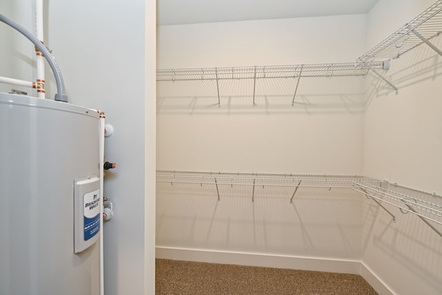 spacious closet featuring carpet and water heater