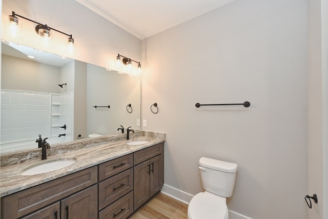 bathroom with a shower, vanity, wood-type flooring, and toilet