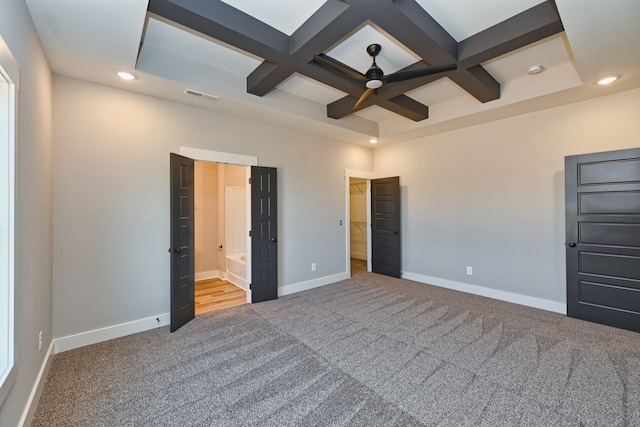 unfurnished bedroom featuring carpet floors, ensuite bath, and coffered ceiling