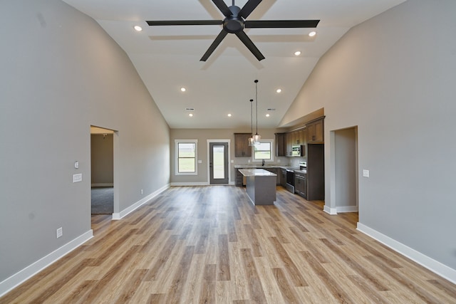 kitchen featuring dark brown cabinets, a kitchen island, appliances with stainless steel finishes, and light hardwood / wood-style flooring