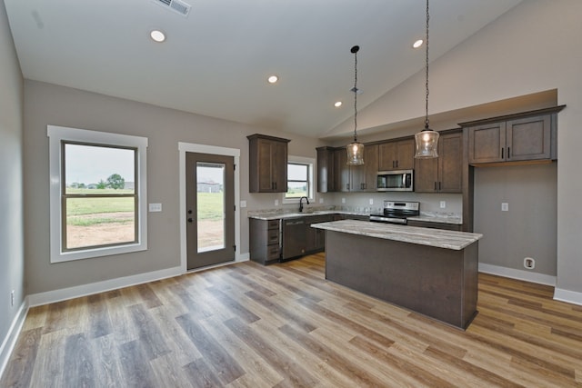 kitchen featuring decorative light fixtures, a kitchen island, light hardwood / wood-style floors, and stainless steel appliances