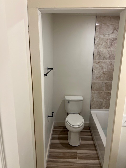 bathroom with toilet and hardwood / wood-style flooring