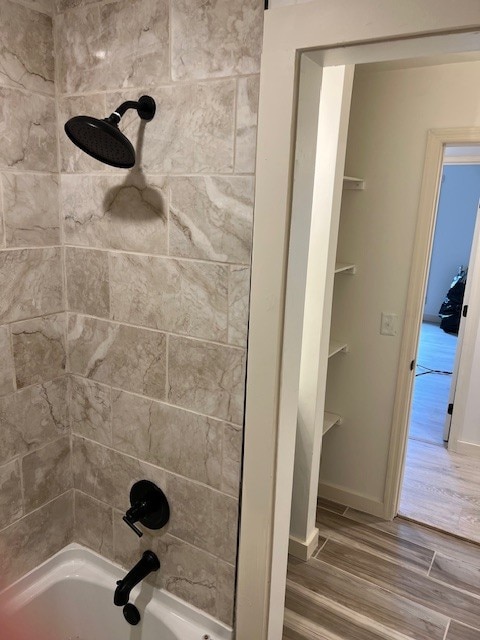 bathroom with wood-type flooring and tiled shower / bath combo