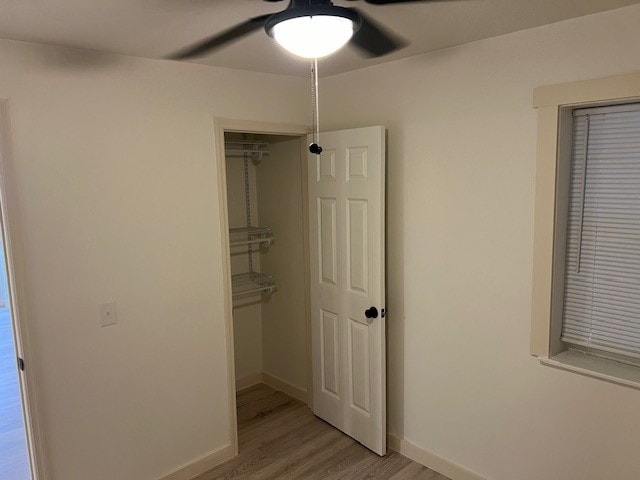 unfurnished bedroom with ceiling fan, a closet, and light hardwood / wood-style floors