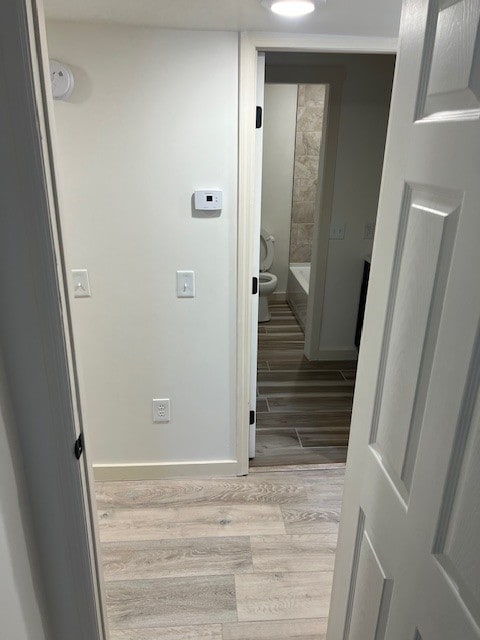 corridor with light hardwood / wood-style floors