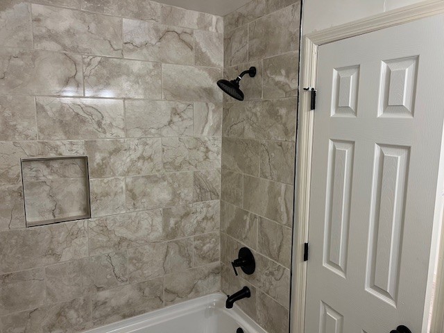 bathroom featuring tiled shower / bath