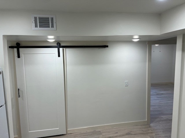 room details with a barn door and wood-type flooring