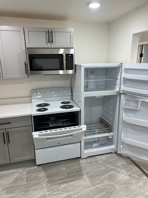 kitchen with gray cabinets, white range with electric cooktop, and fridge