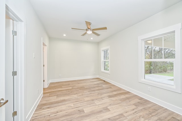 empty room with ceiling fan, a healthy amount of sunlight, and light hardwood / wood-style floors