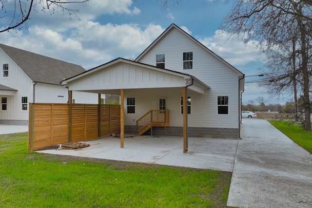 rear view of property featuring a lawn and a carport