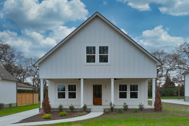 modern farmhouse featuring covered porch, a front lawn, and cooling unit