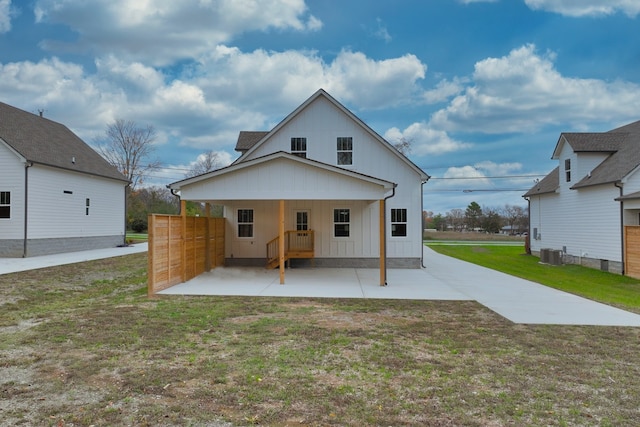 rear view of house featuring a yard and central AC unit