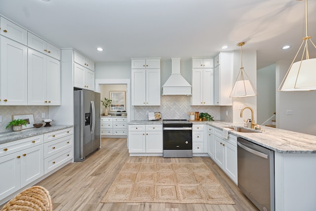 kitchen with white cabinetry, sink, stainless steel appliances, and custom range hood