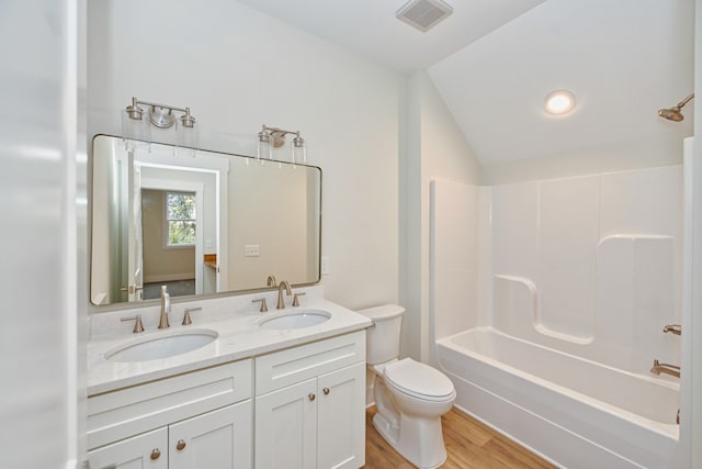 full bathroom featuring bathtub / shower combination, vanity, hardwood / wood-style floors, toilet, and lofted ceiling