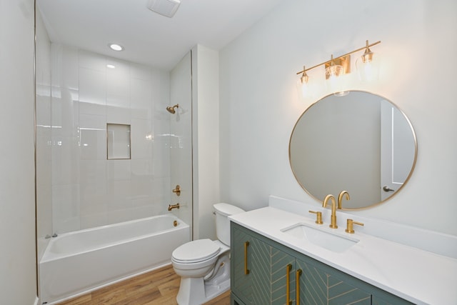 full bathroom featuring toilet, vanity, tiled shower / bath combo, and hardwood / wood-style flooring