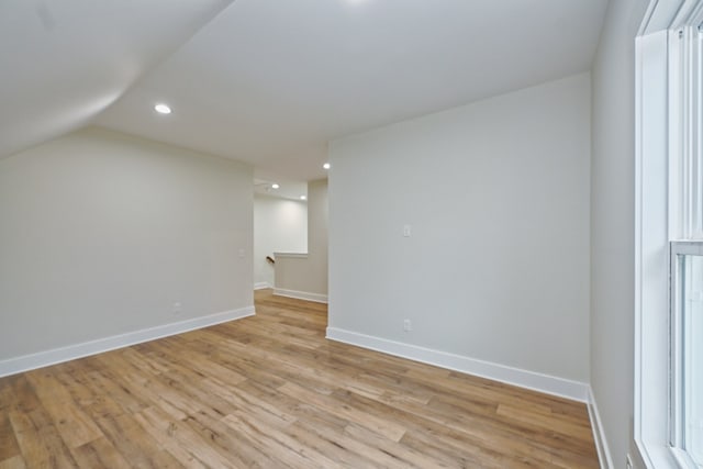 empty room with vaulted ceiling and light wood-type flooring