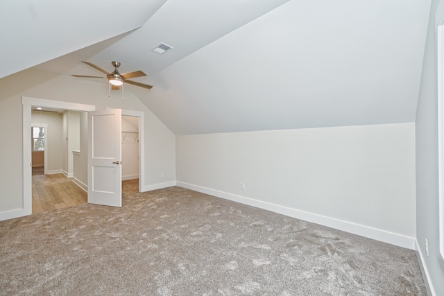 additional living space with light colored carpet, ceiling fan, and lofted ceiling