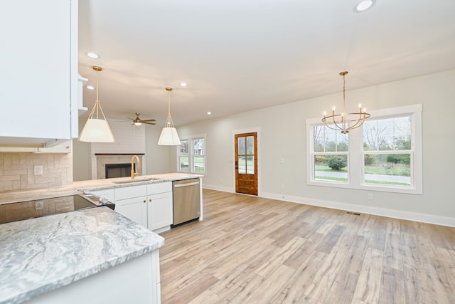 kitchen featuring stainless steel dishwasher, plenty of natural light, white cabinetry, and sink