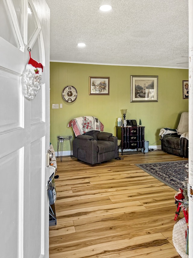 living room featuring wood finished floors, baseboards, and a textured ceiling