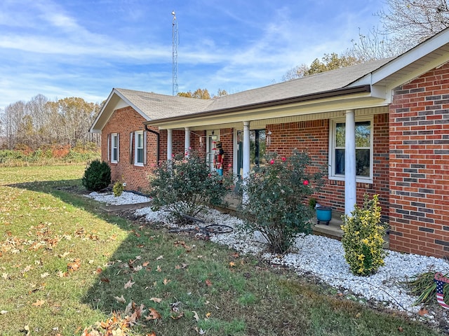 single story home featuring a porch and a front lawn