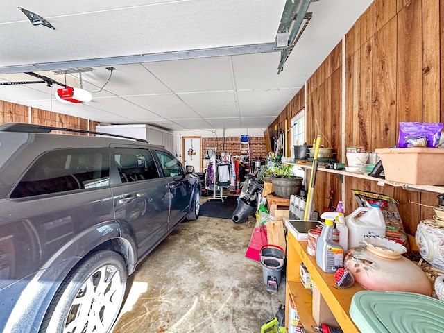 garage featuring wooden walls and a garage door opener