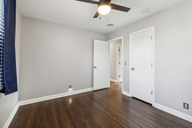 unfurnished bedroom featuring ceiling fan and dark wood-type flooring