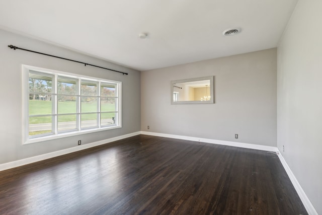 unfurnished room with dark wood-type flooring