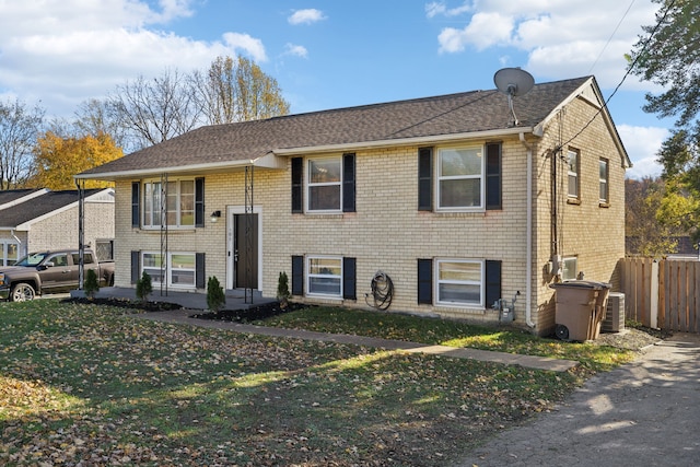 split foyer home with a front yard and cooling unit