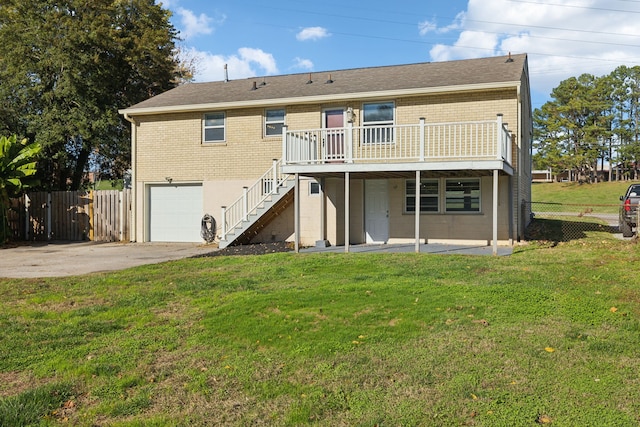 rear view of house with a lawn, a patio area, a deck, and a garage