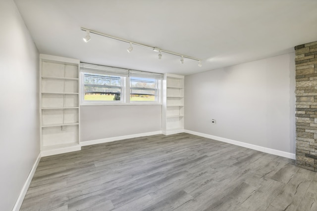 unfurnished room featuring hardwood / wood-style flooring and track lighting