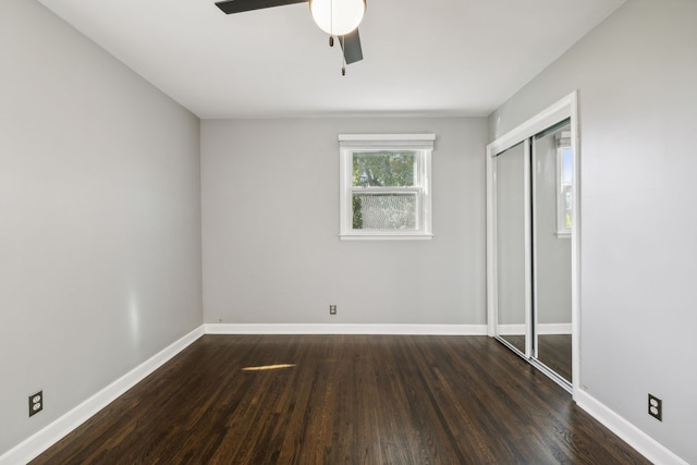 unfurnished bedroom with ceiling fan, a closet, and dark wood-type flooring