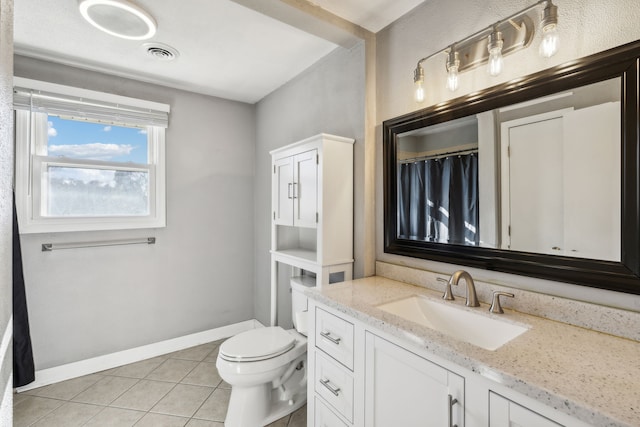 bathroom with tile patterned flooring, vanity, and toilet