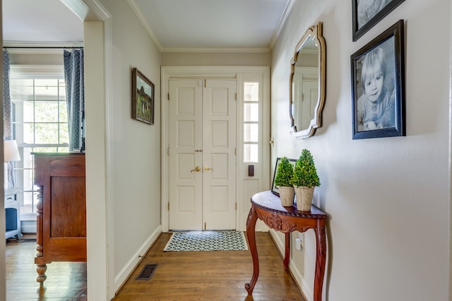 entrance foyer with crown molding and wood-type flooring