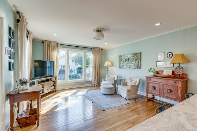 living room featuring crown molding and light hardwood / wood-style floors