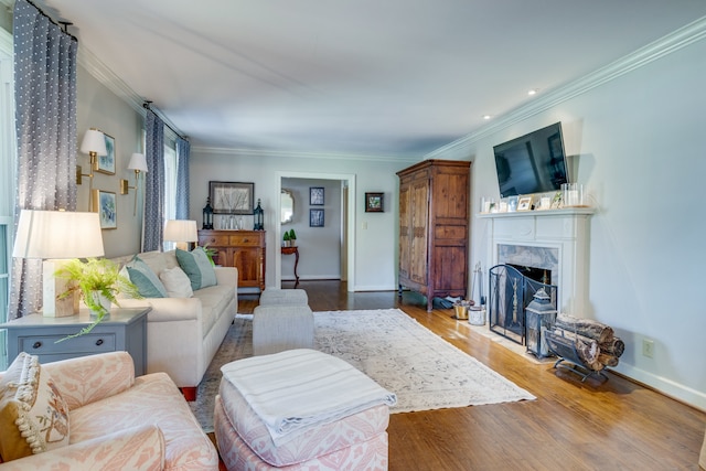 living room featuring a high end fireplace, hardwood / wood-style floors, and ornamental molding