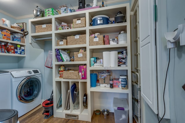 laundry area with hardwood / wood-style floors, separate washer and dryer, and ornamental molding