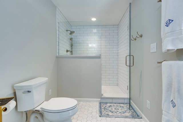 bathroom featuring tile patterned floors, toilet, and a shower with shower door