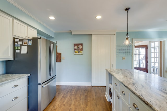 kitchen featuring light wood-type flooring, white cabinetry, ornamental molding, and stainless steel refrigerator