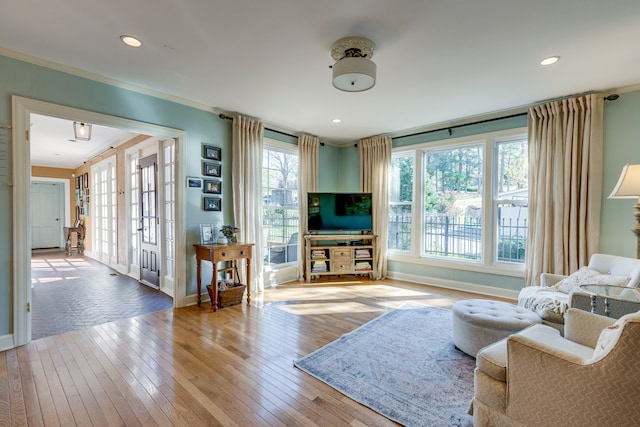 living room with light hardwood / wood-style floors and ornamental molding