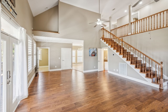 unfurnished living room featuring plenty of natural light, high vaulted ceiling, and hardwood / wood-style floors