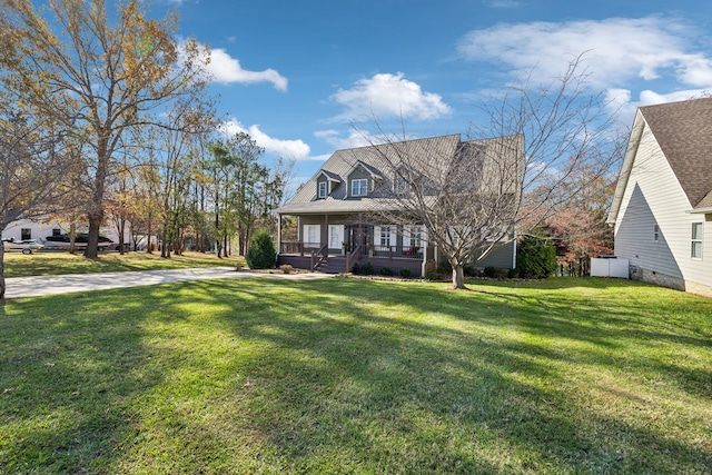 cape cod house featuring covered porch and a front yard