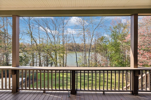 wooden deck featuring a lawn and a water view